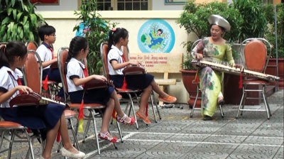 Tran Binh Trong Primary students learn to play Vietnamese zither (Photo: SGGP)